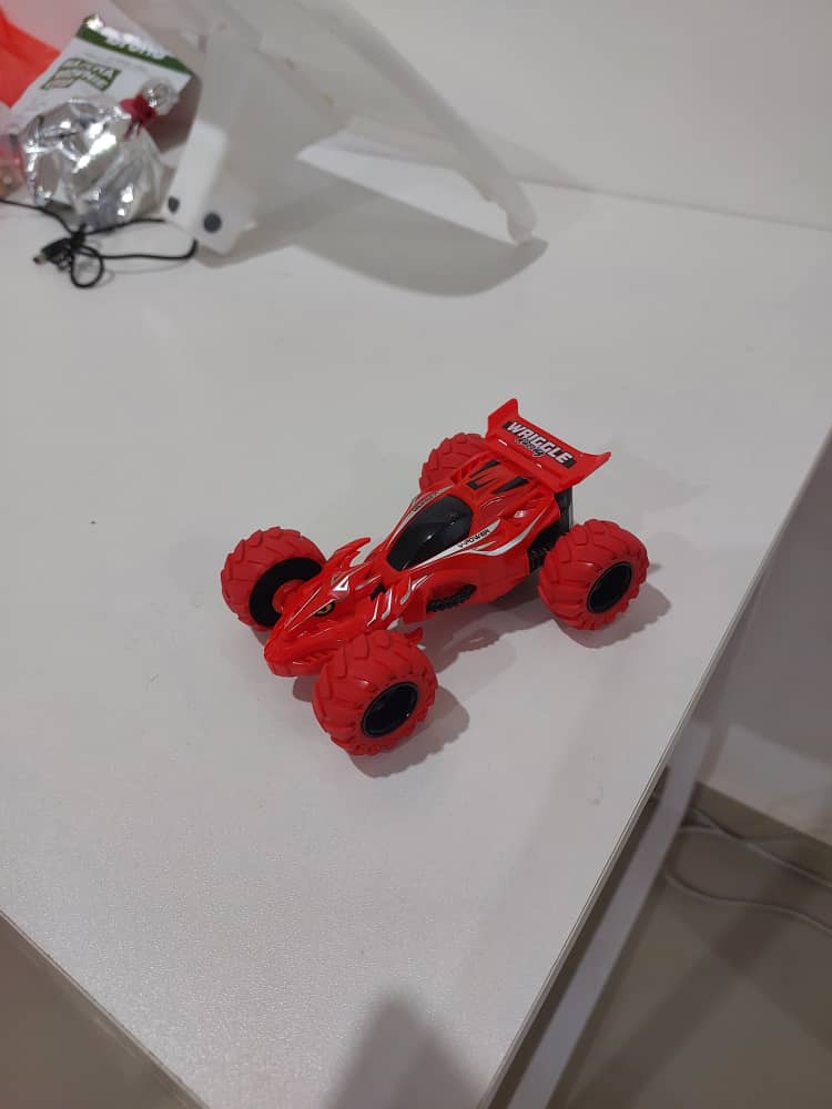 Phone photo of a red toy racing car